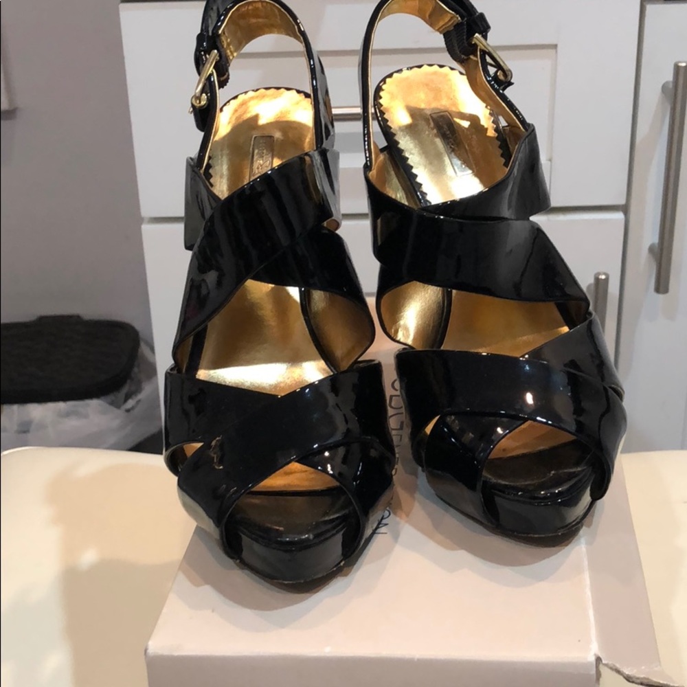 Black patent leather peep toe heels.